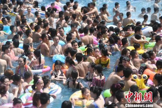 圖為高溫天氣不少市民集中在水中玩耍。　陳超　攝